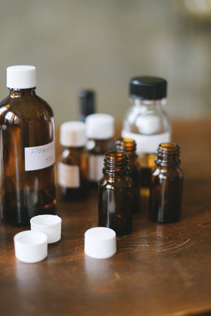 Collection of brown glass bottles with white caps on a wooden table, ideal for medical or cosmetic themes.
